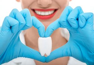 Dentist-holding-tooth-in-heart-shape